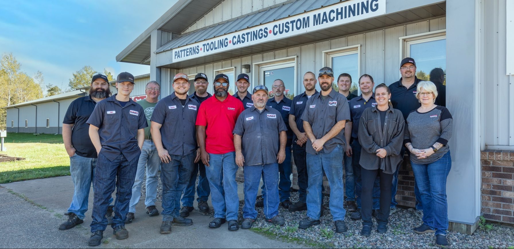 cast corporation team photo in front of building
